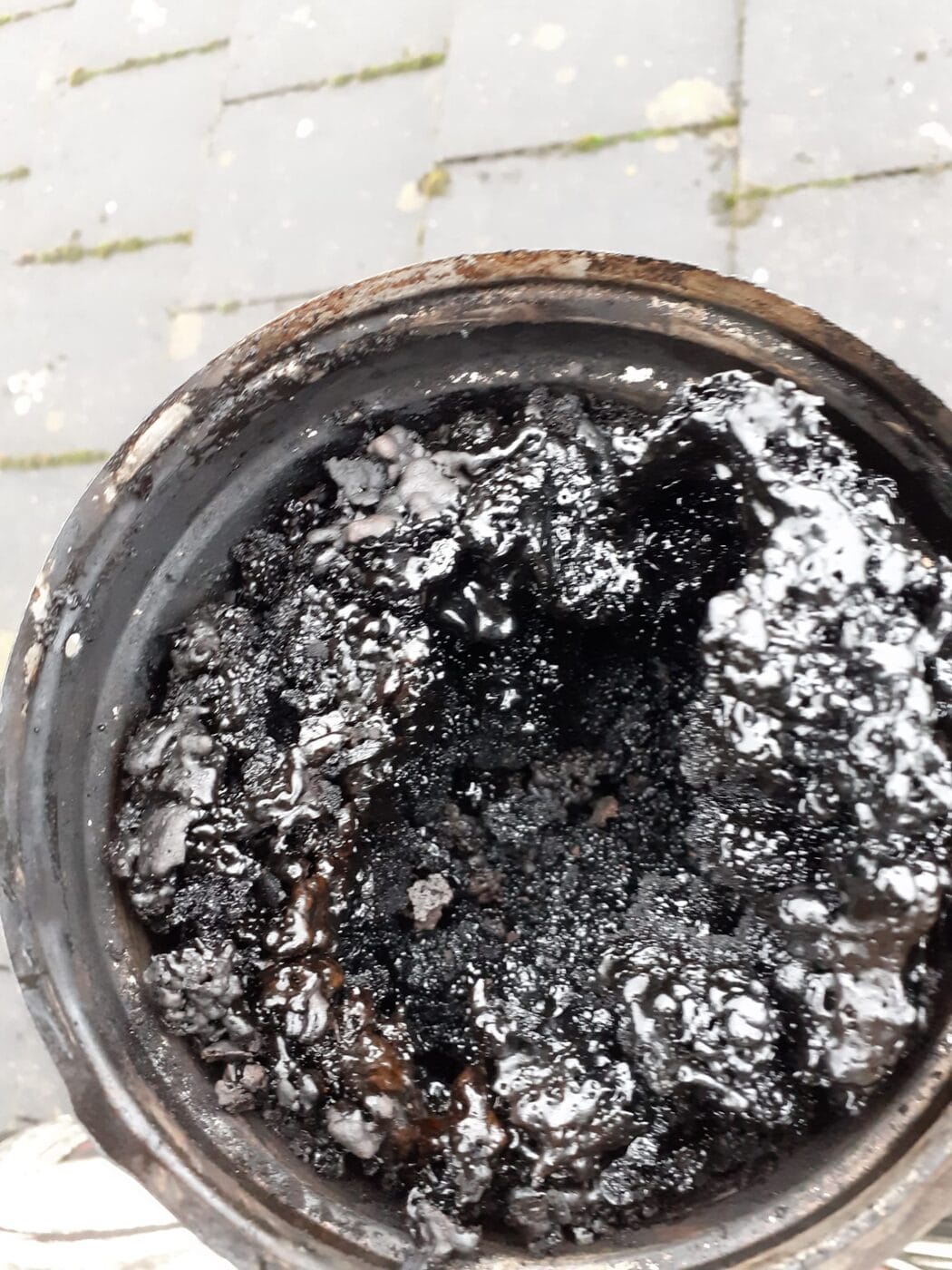 Chimney pot blocked solid with glossy black creosote